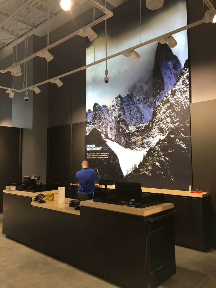 Arc’Teryx service desk and mural of mountains